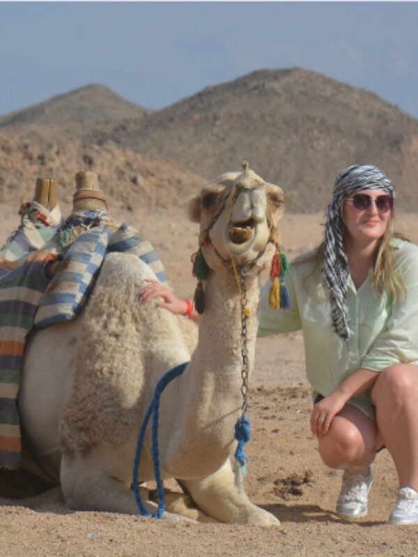 a tourist taking a photo with a camel in the Hurghada Bedouin village